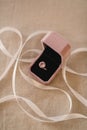 Top view of a pink diamond ring in a velvet box and ribbon on a burlap mat Royalty Free Stock Photo