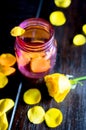 Pink glass jar with yellow rose petals Royalty Free Stock Photo