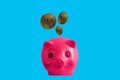 Top view, Pink piggy bank and three coins isolated on cyan background for stock photo. Financial and banking concept. Saving money Royalty Free Stock Photo