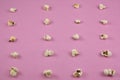 Top view of a pink surface filled with popcorn forming a grid