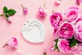 Top view pink tea roses bouquet and white vintage photo frame in shape of heart on pink background. Festive Gift. Valentine`s day Royalty Free Stock Photo