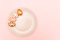 Top view of pink, white and golden decorated eeaster eggs on pink plate on pink background. Trendy holiday backdrop