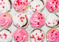 Top view of pink and white Valentine cupcakes decorated with heart sprinkles