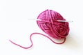 Top view of pink yarn ball with woolen thread on white background