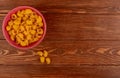 top view of pipe-rigate pasta in bowl on wooden background with copy space