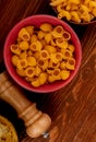 top view of pipe-rigate pasta with other types of pasta in bowls and salt on wooden background