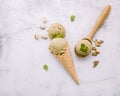 Top view of a pistachio ice cream in a cone with mint leaves and spoon on a white background Royalty Free Stock Photo