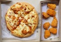 Top view of Pizza in brown paper box and fried chicken. Royalty Free Stock Photo