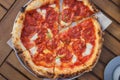 Top view on pizza with chorizo, stracciatella, tomato sauce, green onion on wooden table. Lifestyle