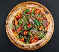 Top view pizza with salami, tomatoes and basil with arugula Royalty Free Stock Photo