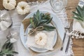 Top view of place setting on a wooden table with white mini pumpkins, sage leaves and crystal glasses for Thanksgiving Day or Royalty Free Stock Photo