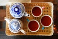 Top view on a plastic tray with two ceramic white-blue teapots and three cups with Thai tea. Royalty Free Stock Photo