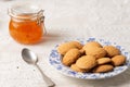 Top view of plate with cookies and jar with peach jam on table with white tablecloth, horizontal Royalty Free Stock Photo