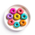 Top view of plate of different donuts with colored glaze.