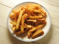 Top view of a plate of French fries and dried tofu on wooden background. Royalty Free Stock Photo