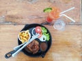 Top view on plate of fresh grilled meat surround by fresh salad, tomatoes, onion, lettuce and two glasses of freshly squeezed Royalty Free Stock Photo