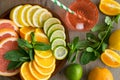 Top view of plate full of sliced juicy citrus, cocktail on table