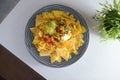 Top view of a plate of nachos with sauce on a white surface Royalty Free Stock Photo