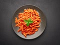 Top view plate of Penne all`Arrabbiata pasta on dark background Royalty Free Stock Photo