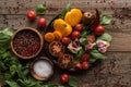 Top view of plate with spinach, garlic and sliced tomatoes near scattered pepper and bowls on wooden table. Royalty Free Stock Photo