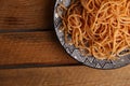 Top view of a plate with tomato spaghetti on a wooden table Royalty Free Stock Photo