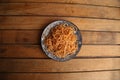 Top view of a plate with tomato spaghetti on a wooden table Royalty Free Stock Photo