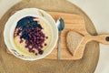 Top view of a plate of wheat porridge with red currants and blueberry jam. A plate of wheat porridge for a healthy