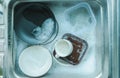 Top view of plates and crockery, coffee mugs in the sink employing dishes with sponge and bubbles of dishwashing liquid, washing Royalty Free Stock Photo