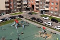 Top view of the playground and parked cars near the entrances in the common courtyard of a residential apartment building