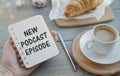 Top view of podcast recording equipment on desk with words new podcast episod