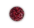 Top view. Pomegranate seeds in a bowl isolated on white background. Background made of red pomegranate seeds.