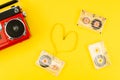 Top view pop vintage red radio with a cassette tape in shape of a heart on a yellow background. Music lover concept Royalty Free Stock Photo