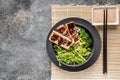 Top view pork meat with a mix of fresh tasty and healthy vegetables, boiled rice, teriyaki sauce in a gray bowl. Gray crockery on