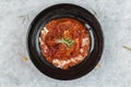 Top view of Pork rib chops steaks boiled with tomato sauce and cheese served in black round plate on washi Japanese paper Royalty Free Stock Photo