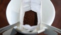 Top view of portable drip coffee bag with ground coffee beans on a white cup Royalty Free Stock Photo