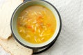 Top view of a portion of a chicken noodle soup, bread slices with cream cheese on the white surface