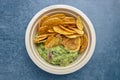 Top view of a portion of fried plantain chips with guacamole