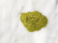 Top view of a portion of organic powdered wheat grass on a gray marble counter top