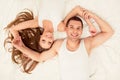 Top view portrait of couple in love lying on bed and holding hands Royalty Free Stock Photo
