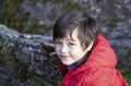 Top view portrait of cute little boy standing next to stone rocks and looking up camera with smiling face, Active child Playing Royalty Free Stock Photo