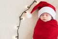 Top View Portrait First Days Life Newborn Cute Funny Sleeping Baby In Santa Hat Wrapped In Red Diaper At White Garland Royalty Free Stock Photo
