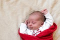 Top View Portrait First Days Of Life Newborn Cute Sleeping Baby In pajamas Wrapped In Red Diaper rug At White soft