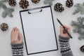 Top view portrait of hand holding pencil and letterhead on clipboard on white background. Christmas, winter,new year Royalty Free Stock Photo