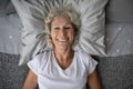 Top view portrait of happy elderly lady resting in bed