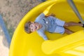 Top View. Portrait of laughing happy boy coming down slide, he looks up at camera. Emotions. Royalty Free Stock Photo