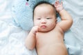 Top view Portrait of a newborn Asian cute baby boy wore blue Infant bodysuit on the bed , Charming Fat baby 5 month old lies in Royalty Free Stock Photo