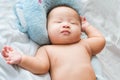 Top view Portrait of a newborn Asian cute baby boy wore blue Infant bodysuit on the bed , Charming Fat baby 5 month old lies in Royalty Free Stock Photo