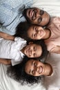 Top view portrait of smiling black family lying on bed Royalty Free Stock Photo