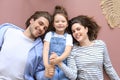 Top view portrait of smiling young parents with little preschooler daughter lying relaxing on warm floor at home