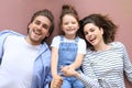 Top view portrait of smiling young parents with little preschooler daughter lying relaxing on warm floor at home